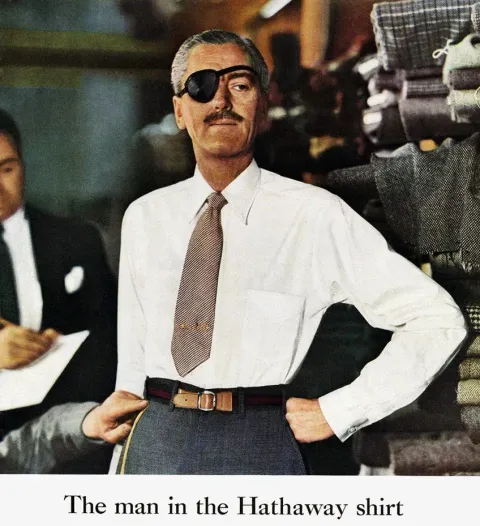 L'uomo con la camicia Hathaway: un modello con benda nera sull'occhio, in camicia bianca, in un negozio di tessuti