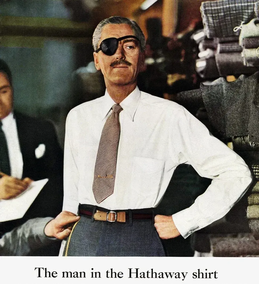L'uomo con la camicia Hathaway: un modello con benda nera sull'occhio, in camicia bianca, in un negozio di tessuti